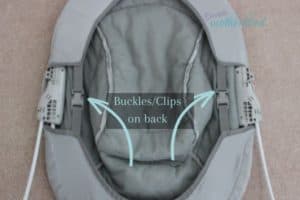 Photo of the back of the bouncer with arrows identifying the clips or buckles