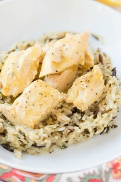 White plate with wild rice and crock pot lemon chicken