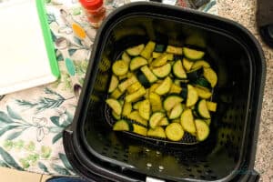 Squash in air fryer basket after adding all ingredients and shaking.